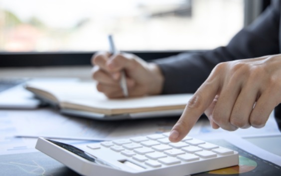 one hand using a calculator, another hand writing