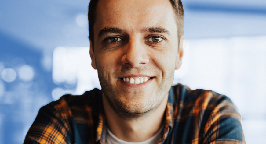 man in a plaid shirt smiling for picture