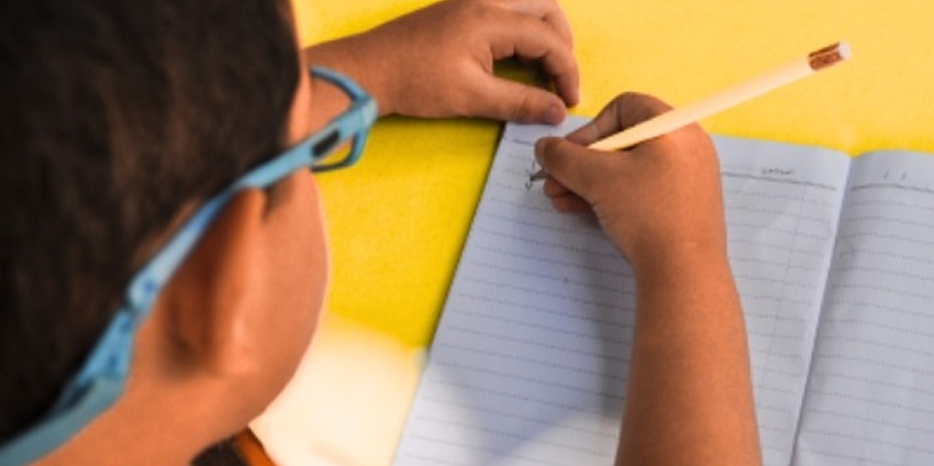 student writing in notebook